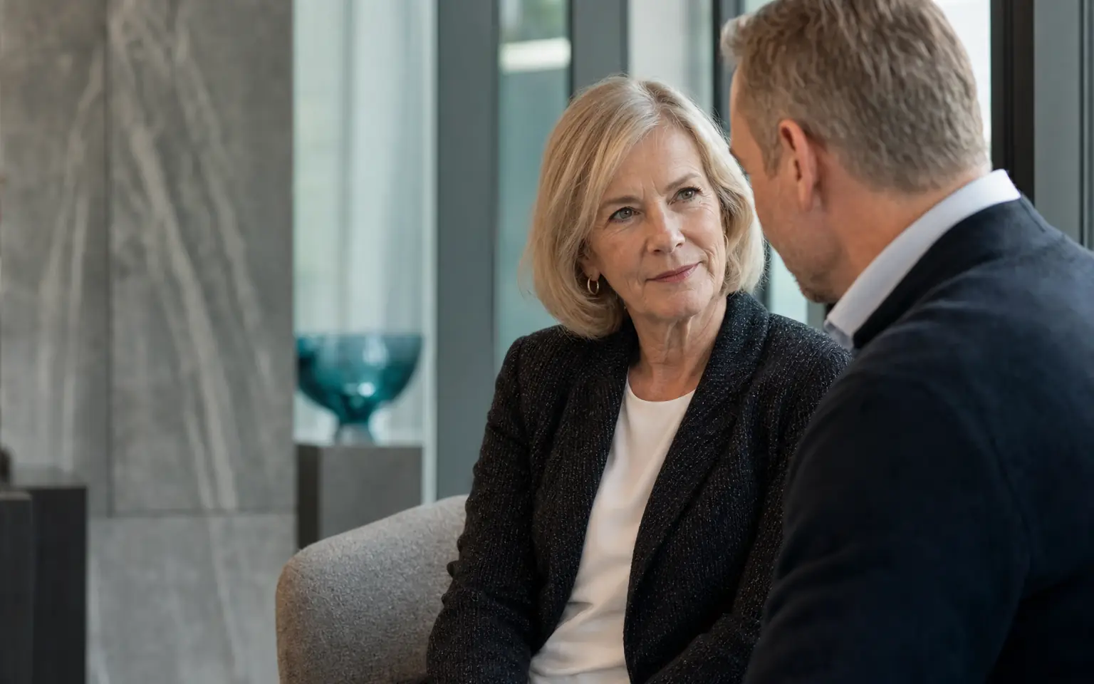 Senior female board advisor speaking privately with an executive